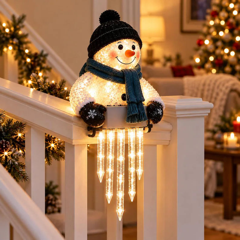 Snowman with black pom-pom hat and teal scarf on an indoor staircase