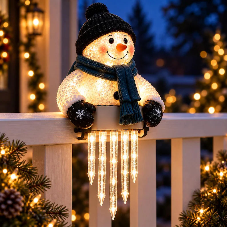 Closeup of lighted snowman on a porch railing at night